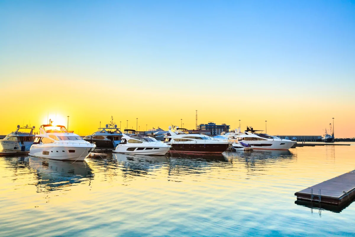 Leisure motor yachts moored in a marina at sunset